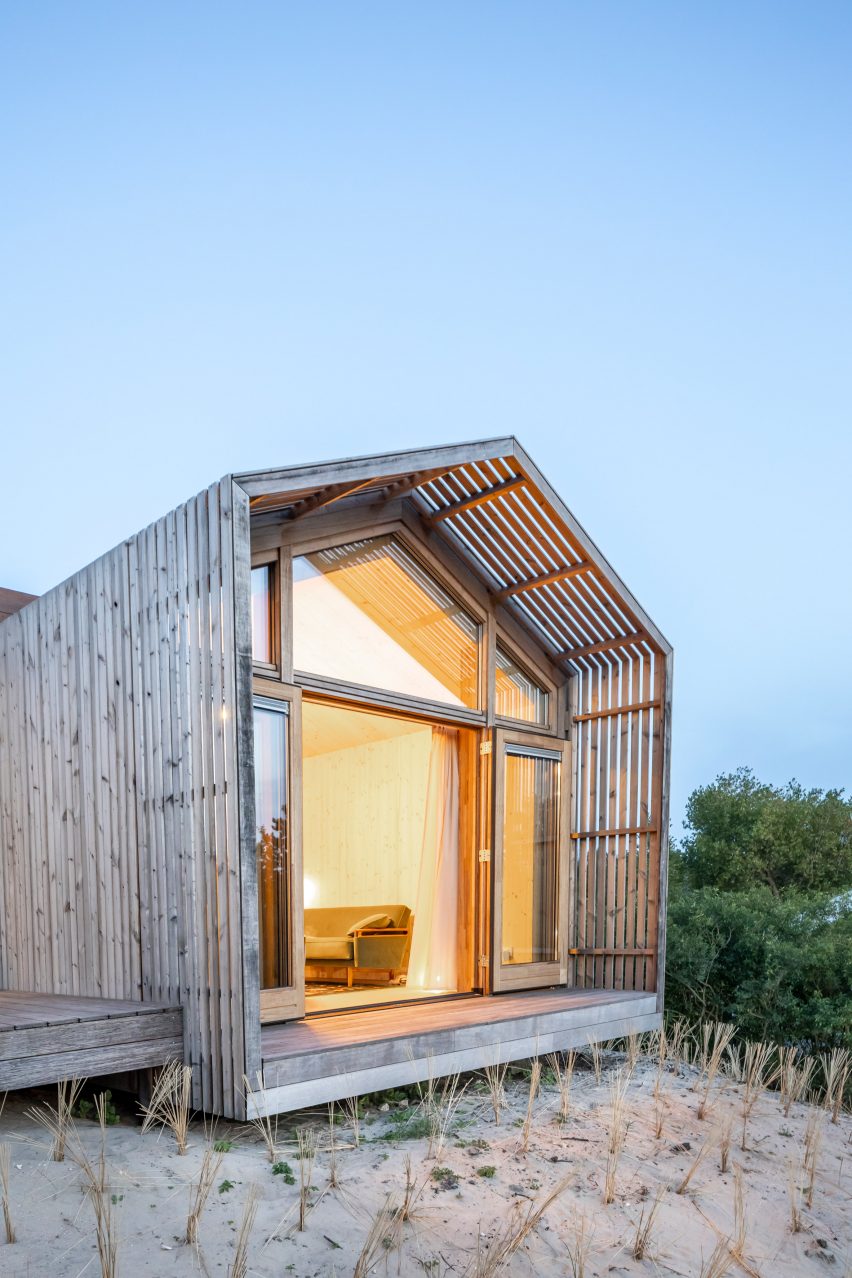 A warmly lit wooden structure on the beach.