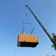 Crane carrying modular unit to site