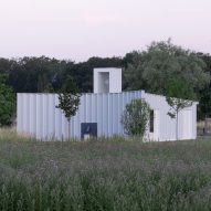 Blue-timber gardeners' workshop topped with illuminating lantern